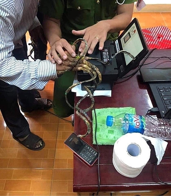 Полицейский в провинции Намдинь помогает Лыу Конг Хюену сканировать отпечатки пальцев. Фото любезно предоставлено полицией округа Джао Туй.