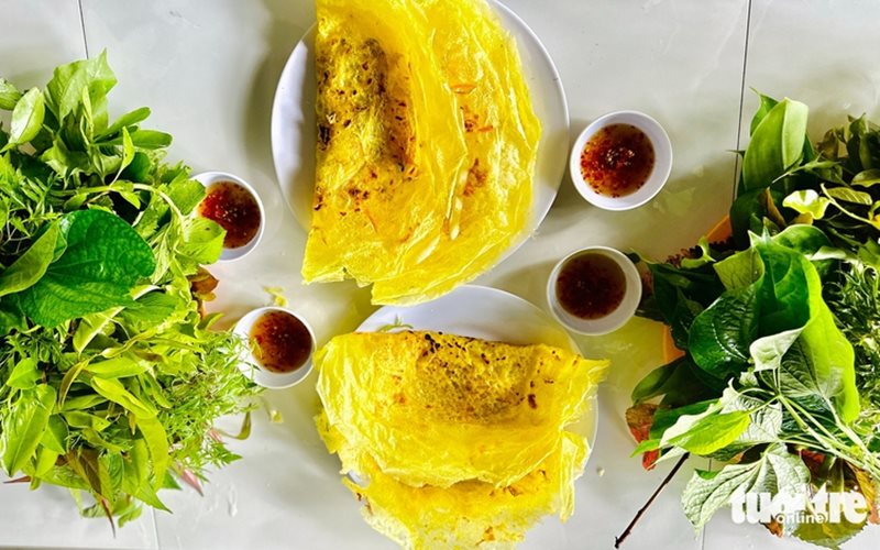 Вьетнамские блинчики Banh xeo подаются с дикой зеленью на горе Кам в провинции Ан Джанг, южный Вьетнам. 