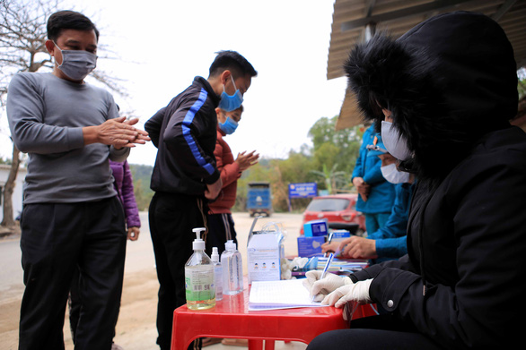 Люди сообщают о своем состоянии здоровья медицинским работникам в провинции Хайзыонг на севере Вьетнама. Фотография: Tuoi Tre News