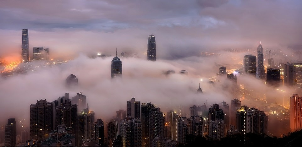 Небоскребы Гонконга, скрытые в густых белых облаках перед рассветом, - работа Cp Lau.