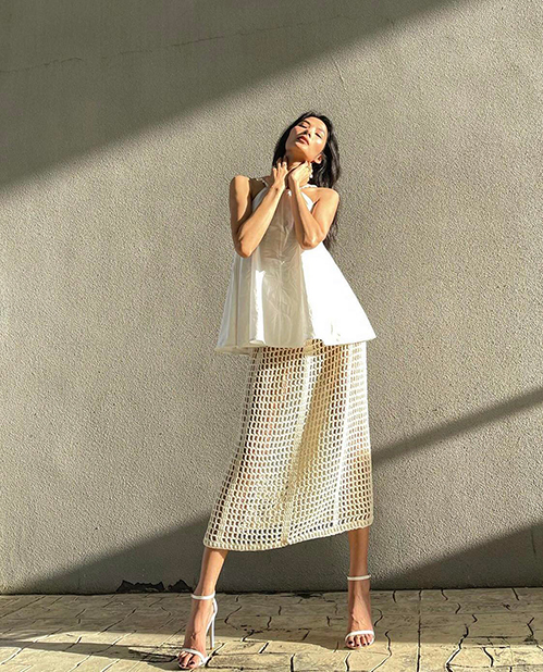 Модель Хоанг Туй выбирает белый наряд под солнечным светом.