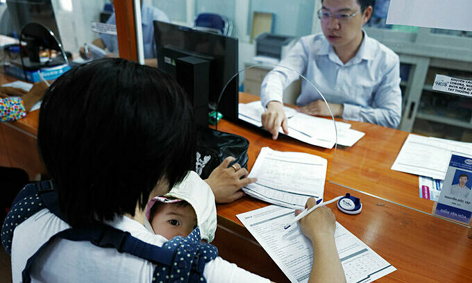 Мать отвозит свою шестимесячную дочь в Ханойский центр обслуживания сотрудников в районе Кау Джэй, чтобы подать заявление на пособие по безработице, июнь 2020 года. Данные центра показывают, что женщины составляют 65 процентов людей, претендующих на пособие по безработице. Фото VnExpress / Ngoc Thanh