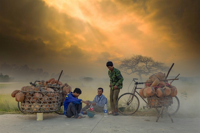 Продавцы глиняных горшков отдыхают на обочине дороги. Фото: vannghenghean.vn