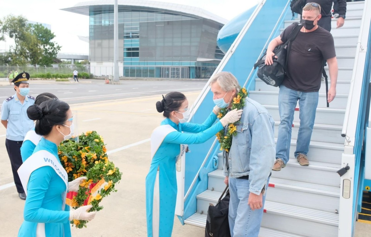 Сотрудники авиакомпании Vietnam Airlines приветствуют иностранных туристов, прибывающих в международный аэропорт Да Нанг, 17 ноября 2021 года. Фото: Vietnam Airlines