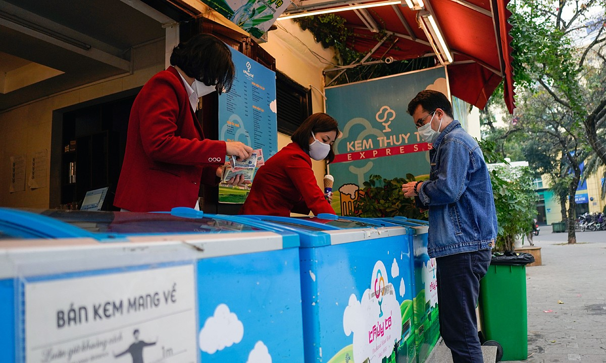 Мужчина покупает мороженое в магазине в районе Хоан Кием в Ханое, 26 декабря 2021 года. Фото: VnExpress/Pham Chieu