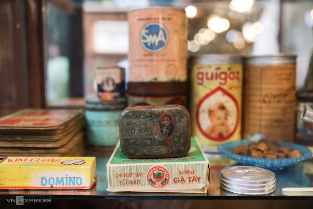 Небольшой уголок стеклянного шкафа содержит много знакомых предметов для каждой семьи в Сайгоне, таких как банзам, мыла, швейные нитки, молочные банки Guigoz... Изюминкой является мыло Co Ba - бренд, известный для вьетнамцев в начале 20-го века.