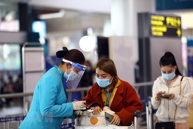 Сотрудники Vietnam Airlines оказывают поддержку пассажирам в процедуре электронного декларирования здоровья. (Фото: ВИА)
