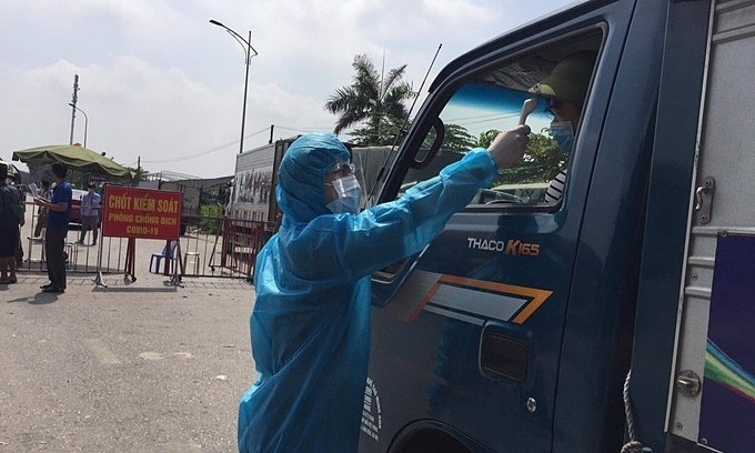 Медицинский работник проверяет температуру у водителя в провинции Бак Нинь. Фото: VnExpress/Ngoc Ly.