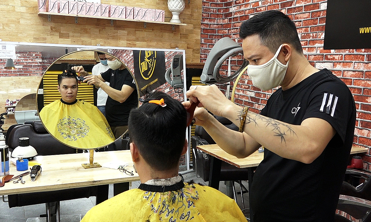Клиент стрижётся в парикмахерской на улице Нгуен Хонг в Ханое 22 июня 2021 года Фото: VnExpress/The Quynh.