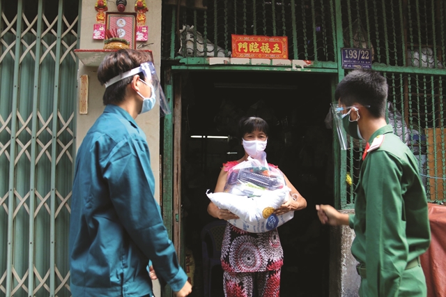 Солдаты отдают товары жителю в переулке на улице Нгуен Тиеу Ла, район 10 города Хошимина. Фото: VNA/VNS