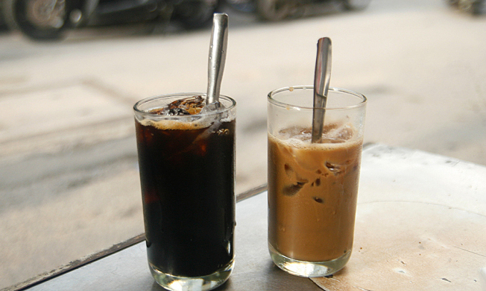 Две чашки черного кофе со льдом (слева) и кофе со сгущенным молоком в магазине на улице Фан Динь Фунг в Хошимине. Фото VnExpress/