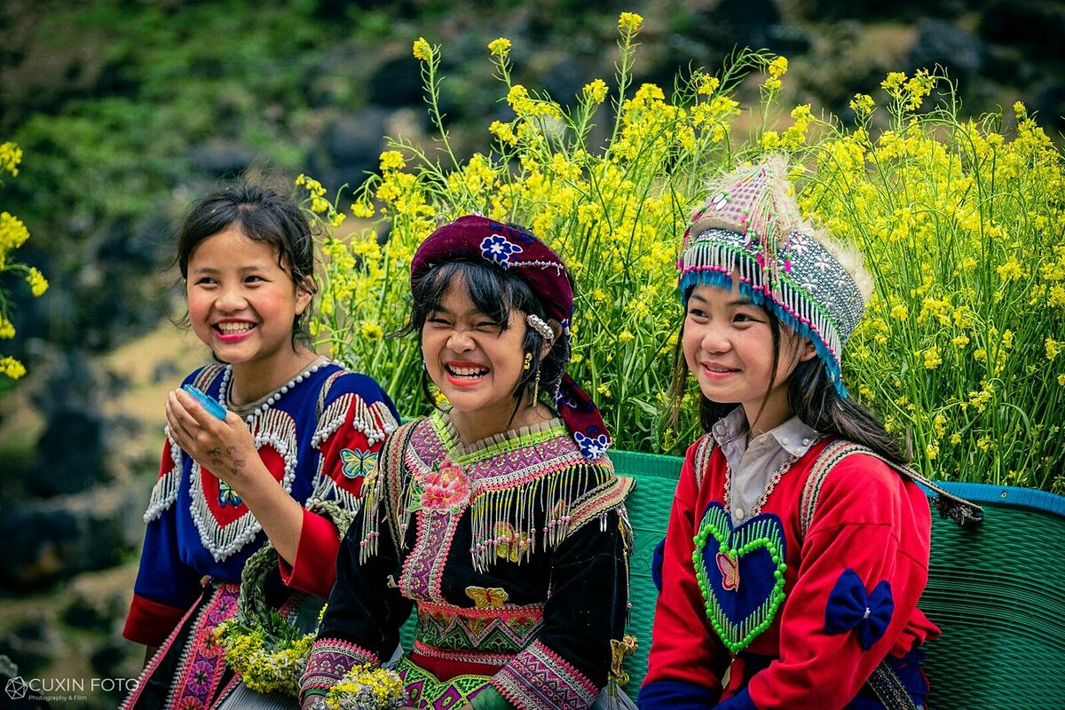 Дети улыбаются с цветами на спине в ротанговых корзинах в провинции Ха Джанг. Фото: Pham Xuan Quy