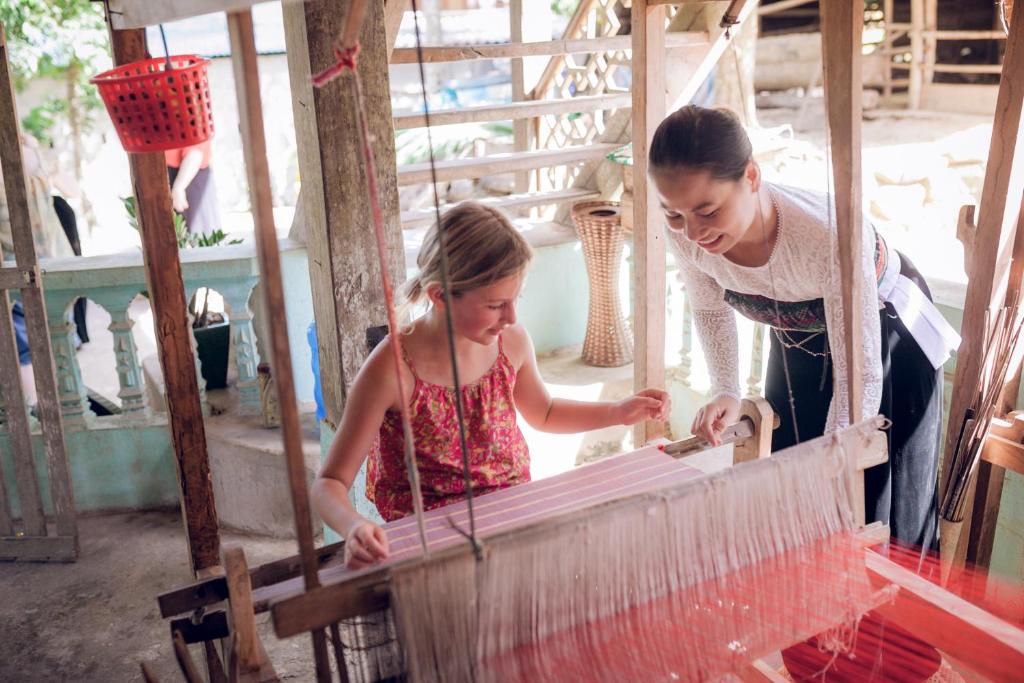 Иностранные туристы узнают о традициях ткачества белых тайцев в деревне Лак. Фото Зы Хи