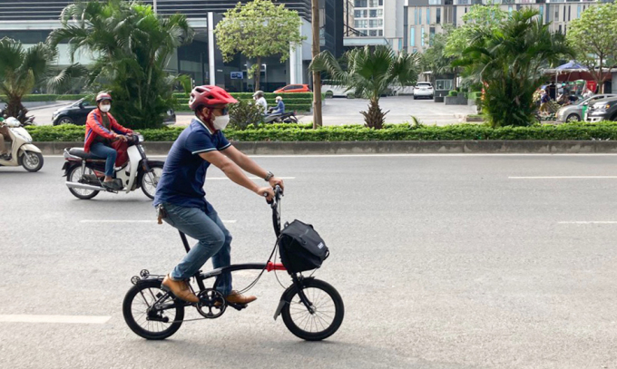 Ха Суан Нам едет на велосипеде на работу в июне 2022 года. 
