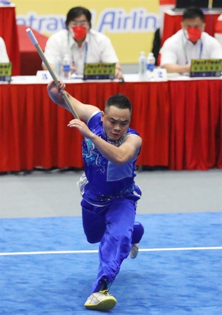 Мастер боевых искусств ушу Фам Куок Хань выступает и берет серебро в мужском соревновании nangun на SEA Games 31 в мае. Фото: VNA/VNS
