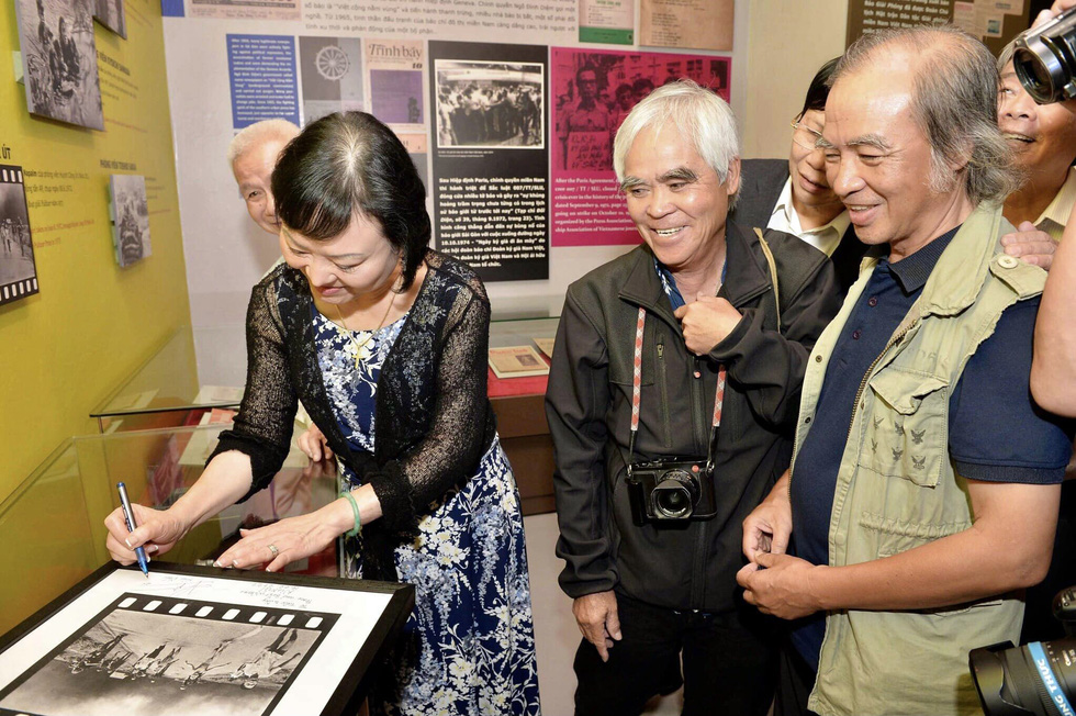 Ник Ут и Фан Тхи Ким Фук подписывают фотографию «Напалмовой девушки» во время встречи в Музее прессы Вьетнама в Ханое, Вьетнам. Фото: Supplied